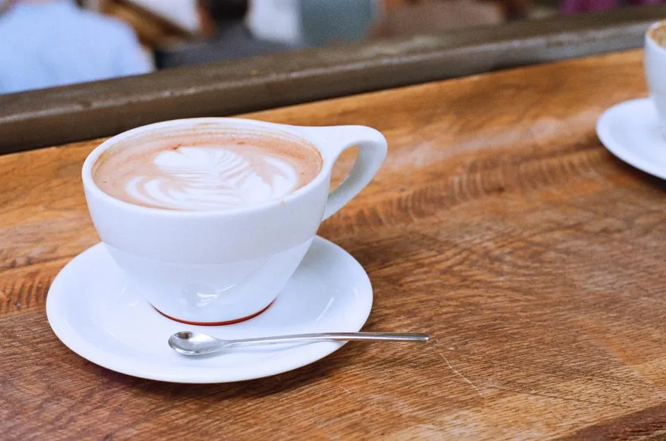 Taza de café sobre mesa de madera (imagen referencial)
